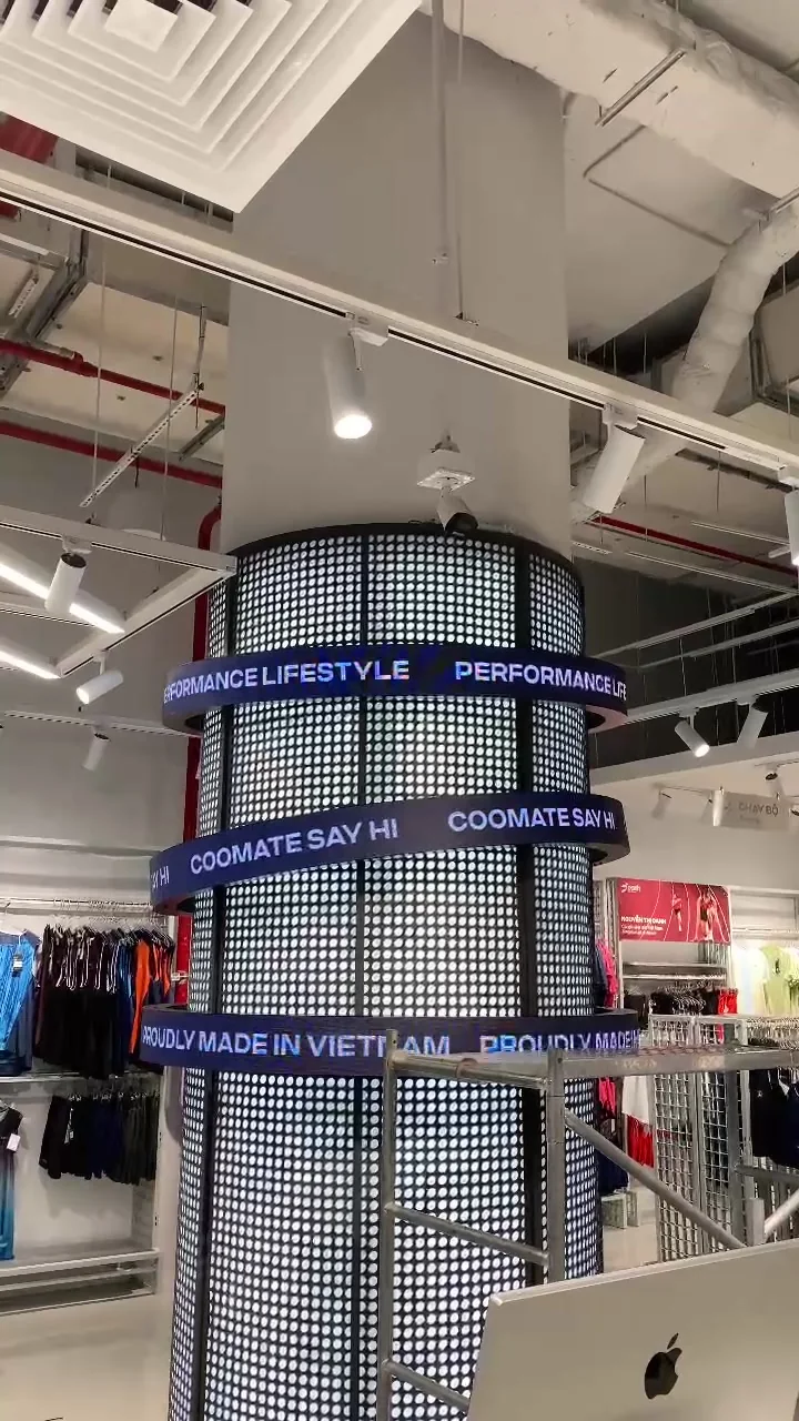 Ba vòng LED dẻo chạy chữ COOLMATE SAY HI và PERFORMANCE LIFESTYLE quanh cột LED lưới đang sáng tại cửa hàng Coolmate Hanoi Centre